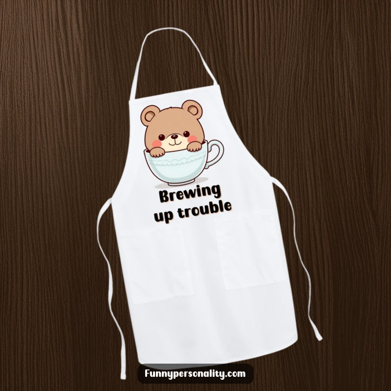 Funny apron featuring a curious bear character smiling as it peeks into a giant teacup, adding humor to kitchen tasks.