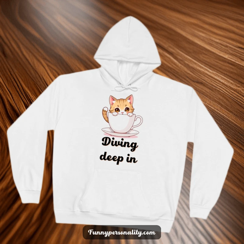 Funny cat hoodie: a warm hoodie featuring a curious cat character peering into an impossibly large teacup, looking fascinated.