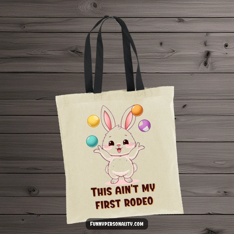 Funny tote bag featuring a fluffy bunny character juggling three vibrant balls, a practical and humorous accessory for everyday use.